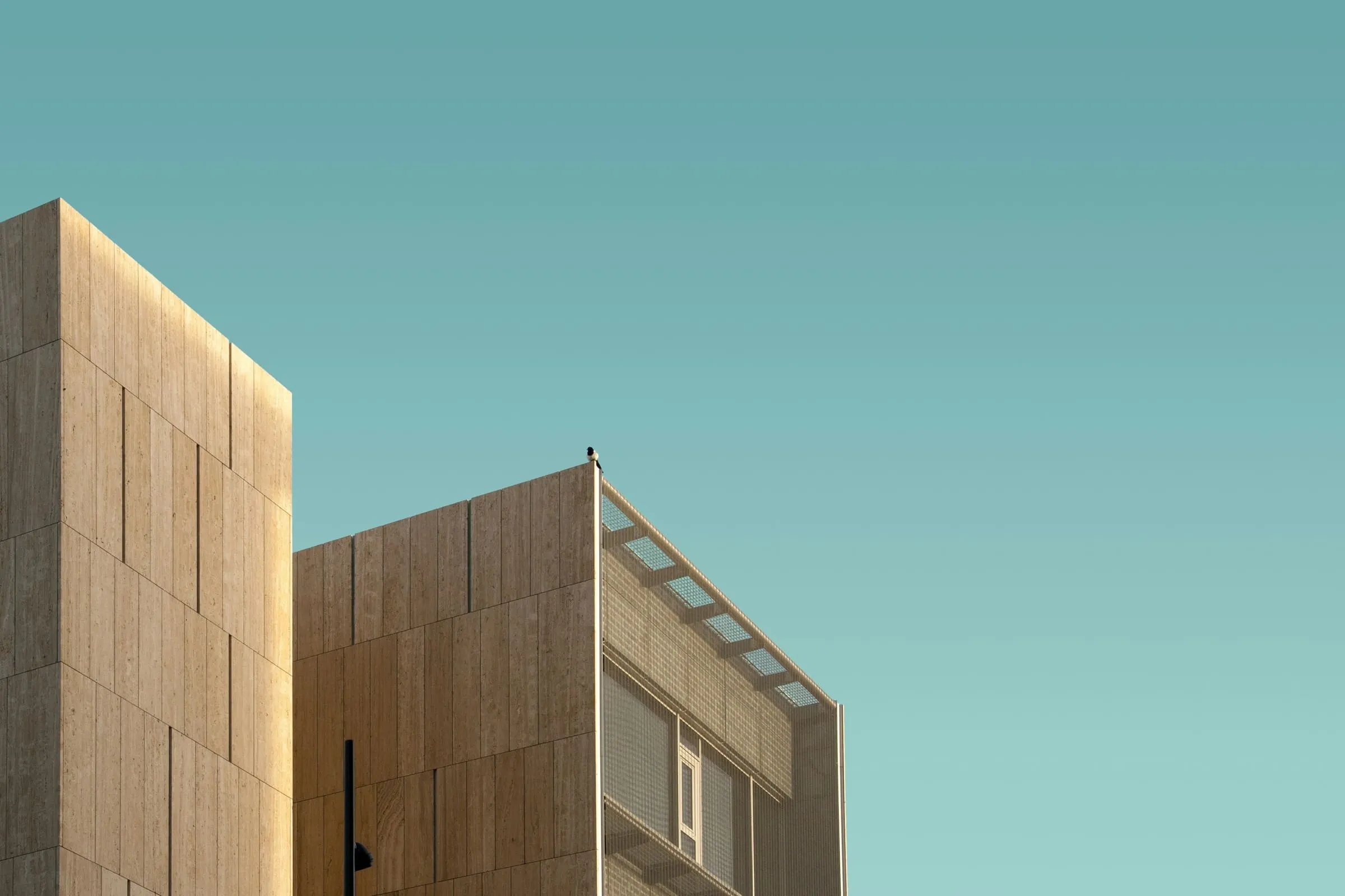 A tall structural frame rising in an unbroken vertical rhythm against clear sky