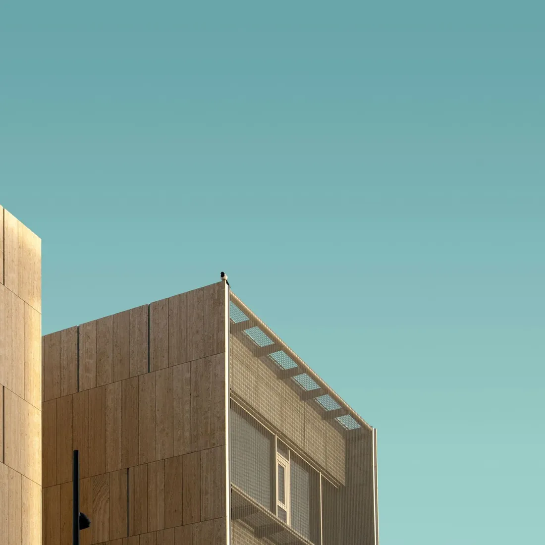A tall structural frame rising in an unbroken vertical rhythm against clear sky