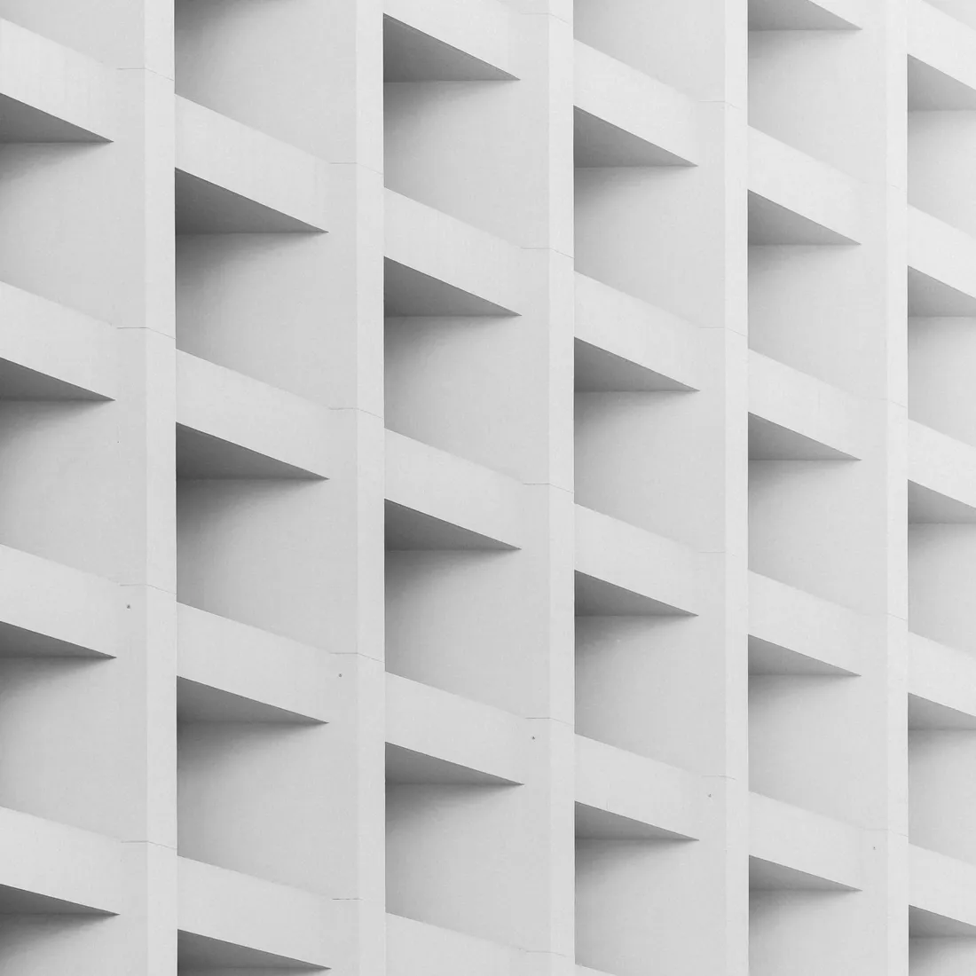 A facade of repeating cast panels forming a continuous geometric pattern