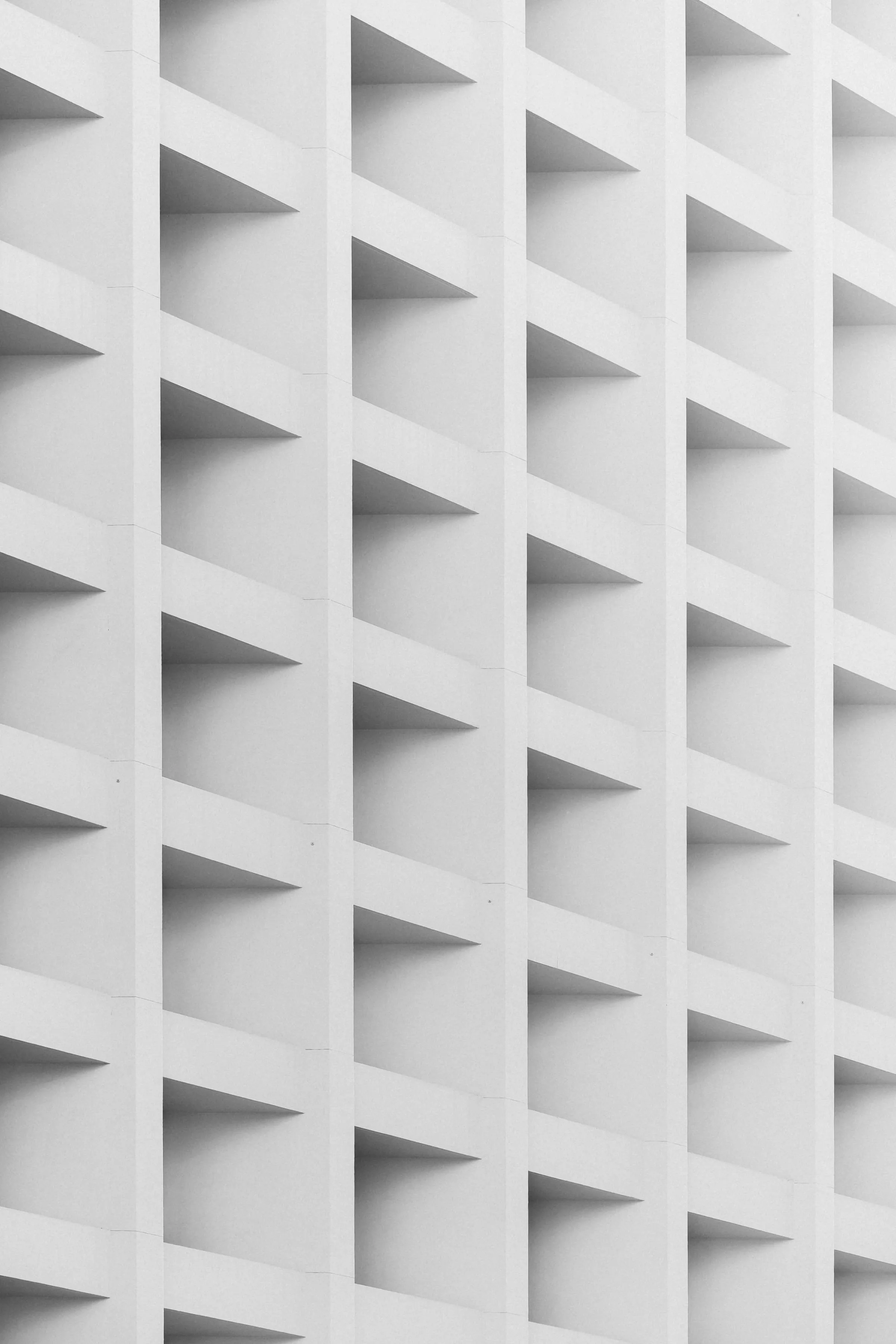 A facade of repeating cast panels forming a continuous geometric pattern