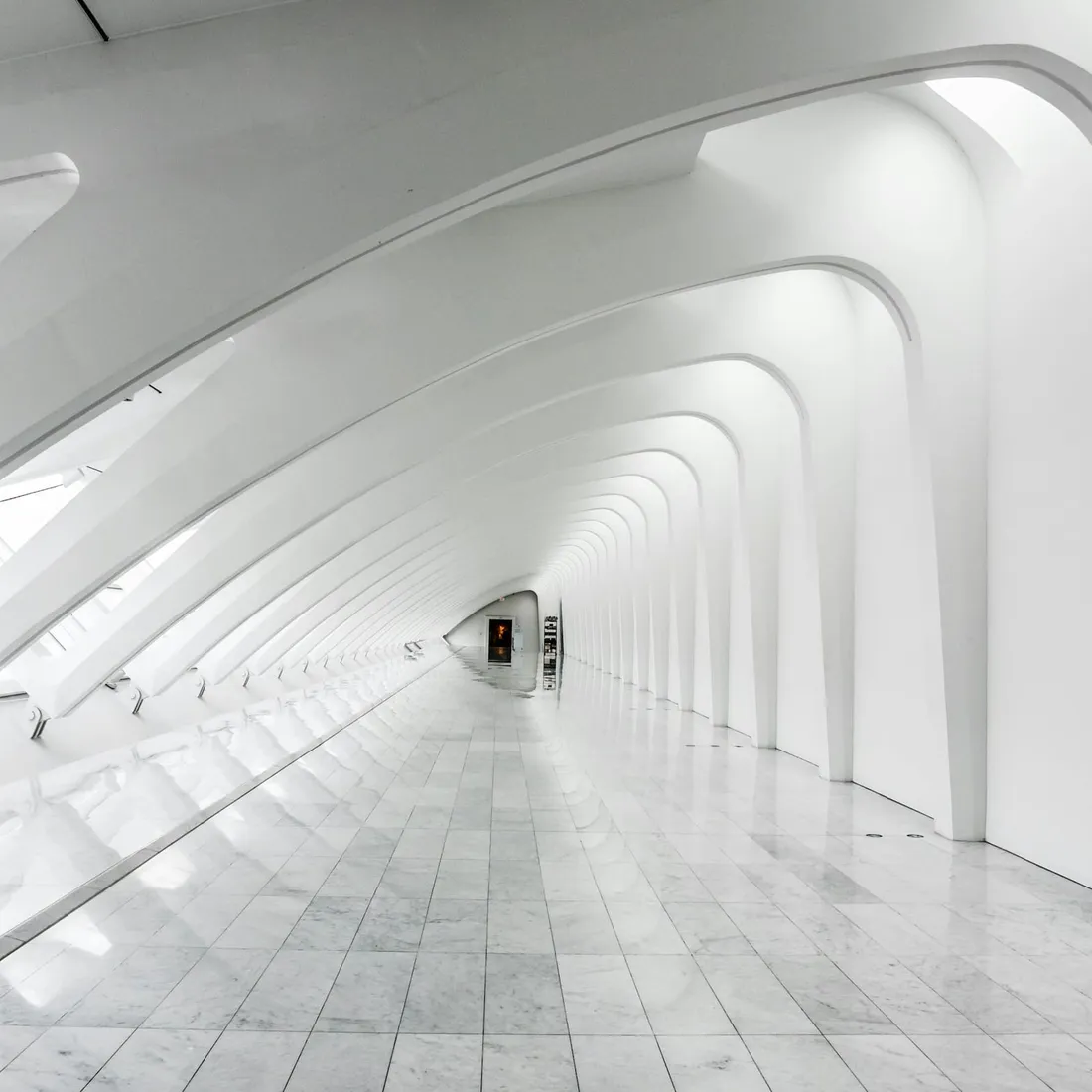 A white painted building holding a hard diagonal of daylight across its face