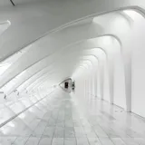 A white painted building holding a hard diagonal of daylight across its face
