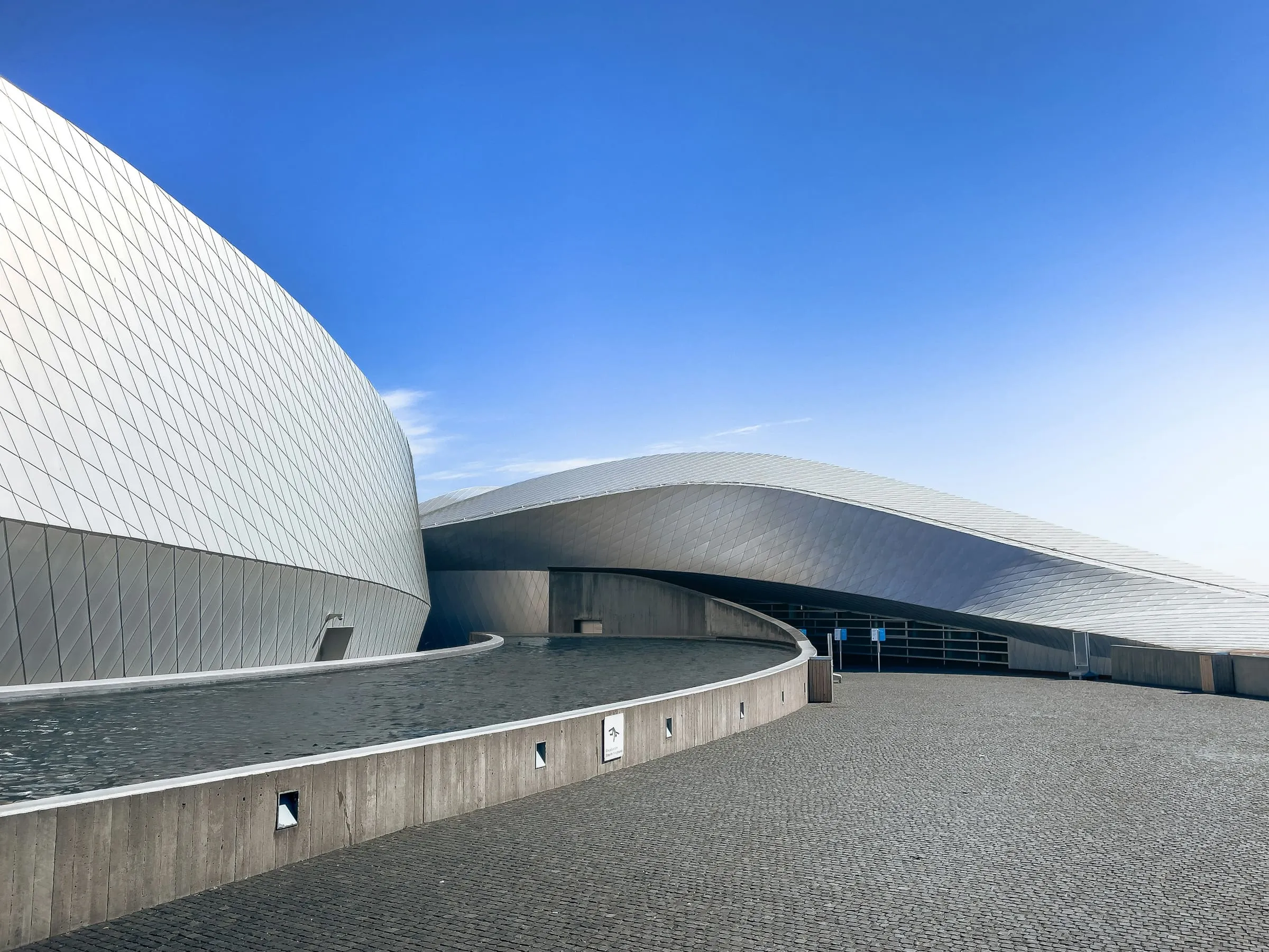 A curved building edge sweeping across an otherwise empty sky