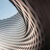 A concrete facade photographed from below, its floors receding into an even sky