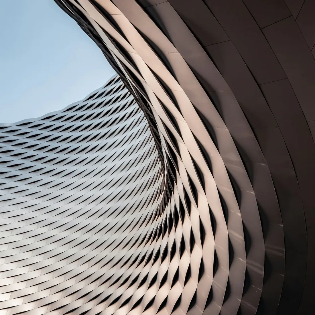A concrete facade photographed from below, its floors receding into an even sky