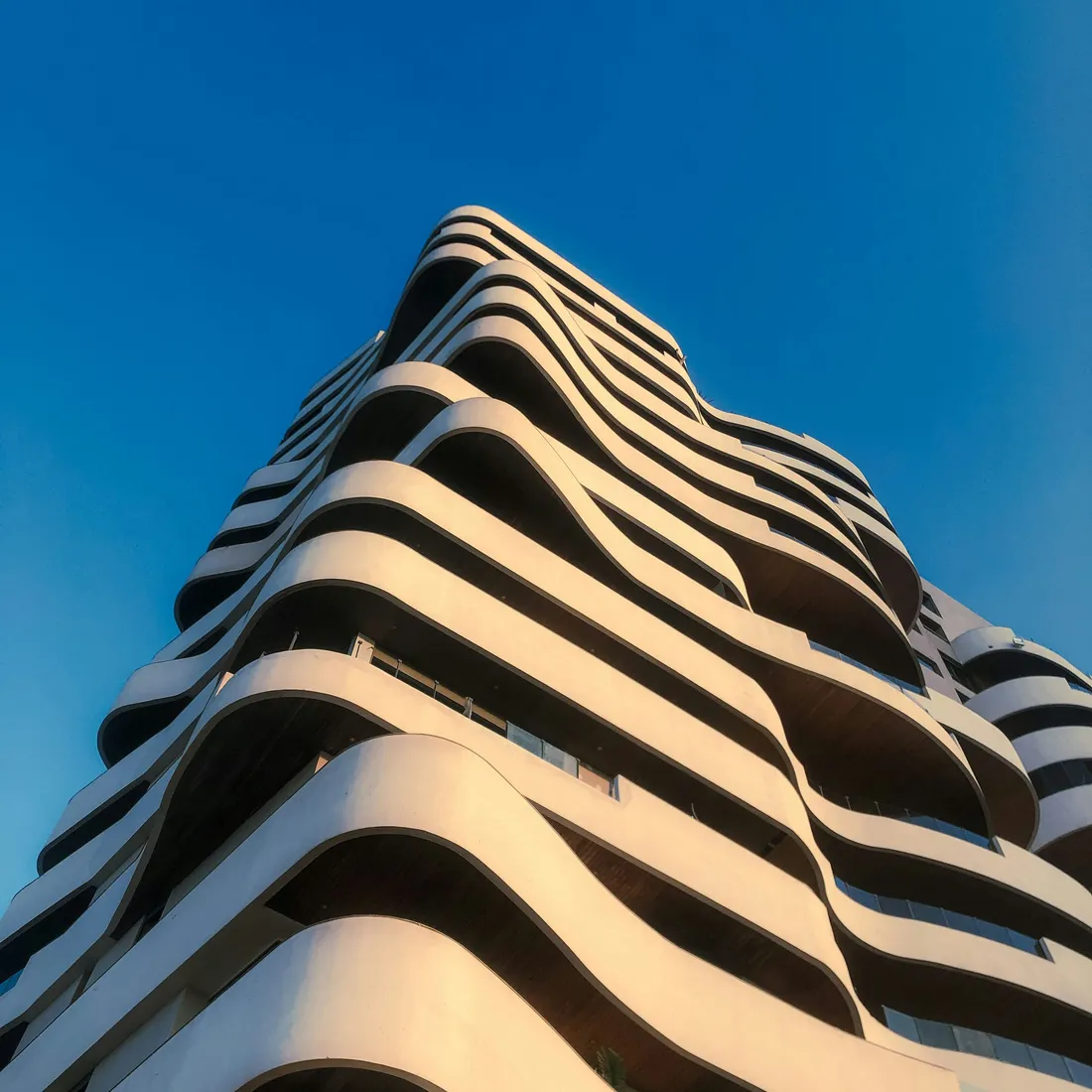 A tall residential slab, its windows repeating in an unbroken grid