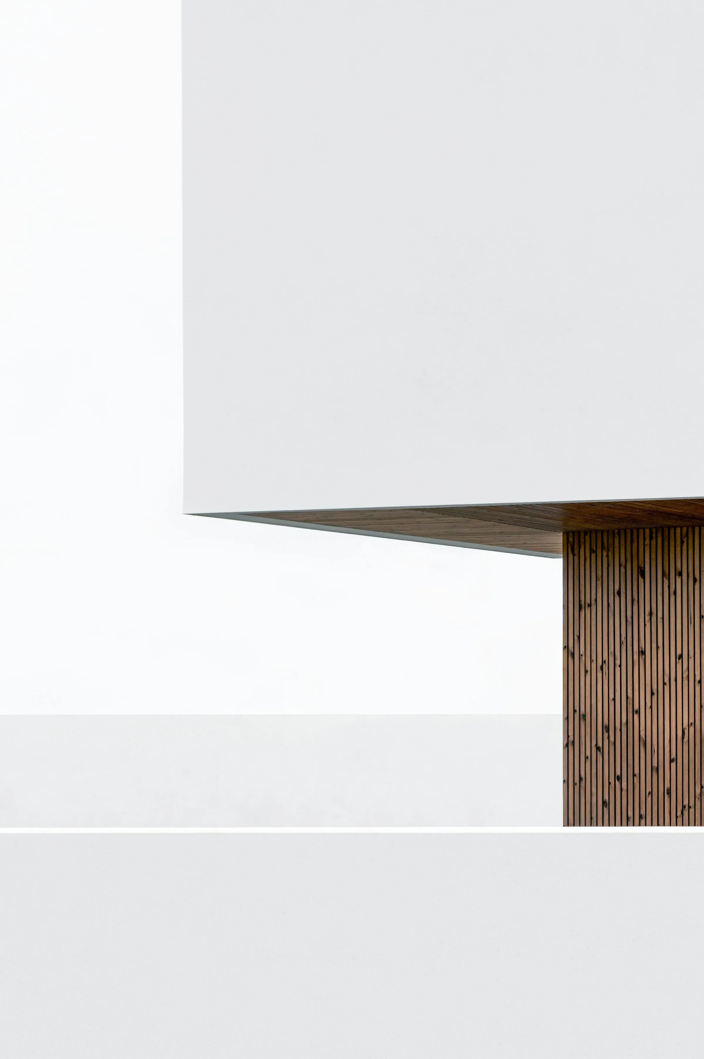 A plain painted wall holding a single soft gradient of daylight