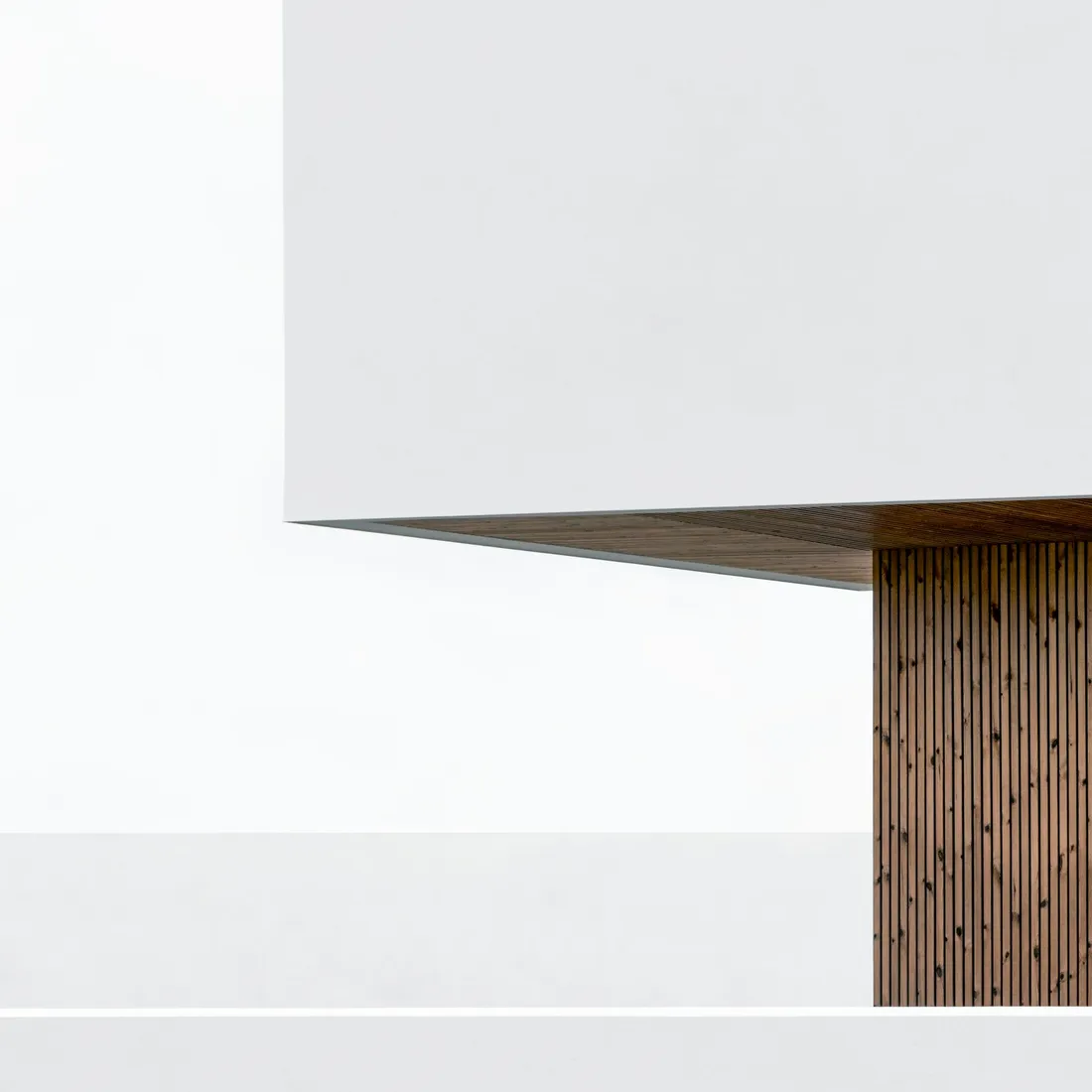 A plain painted wall holding a single soft gradient of daylight