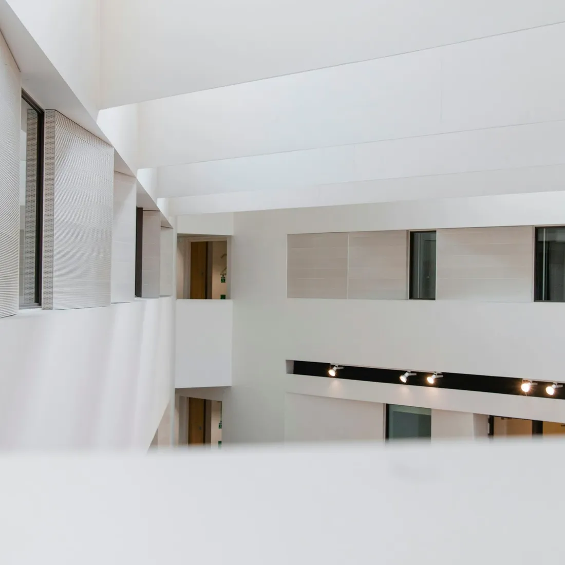 A white concrete building whose long horizontal opening runs the width of the frame