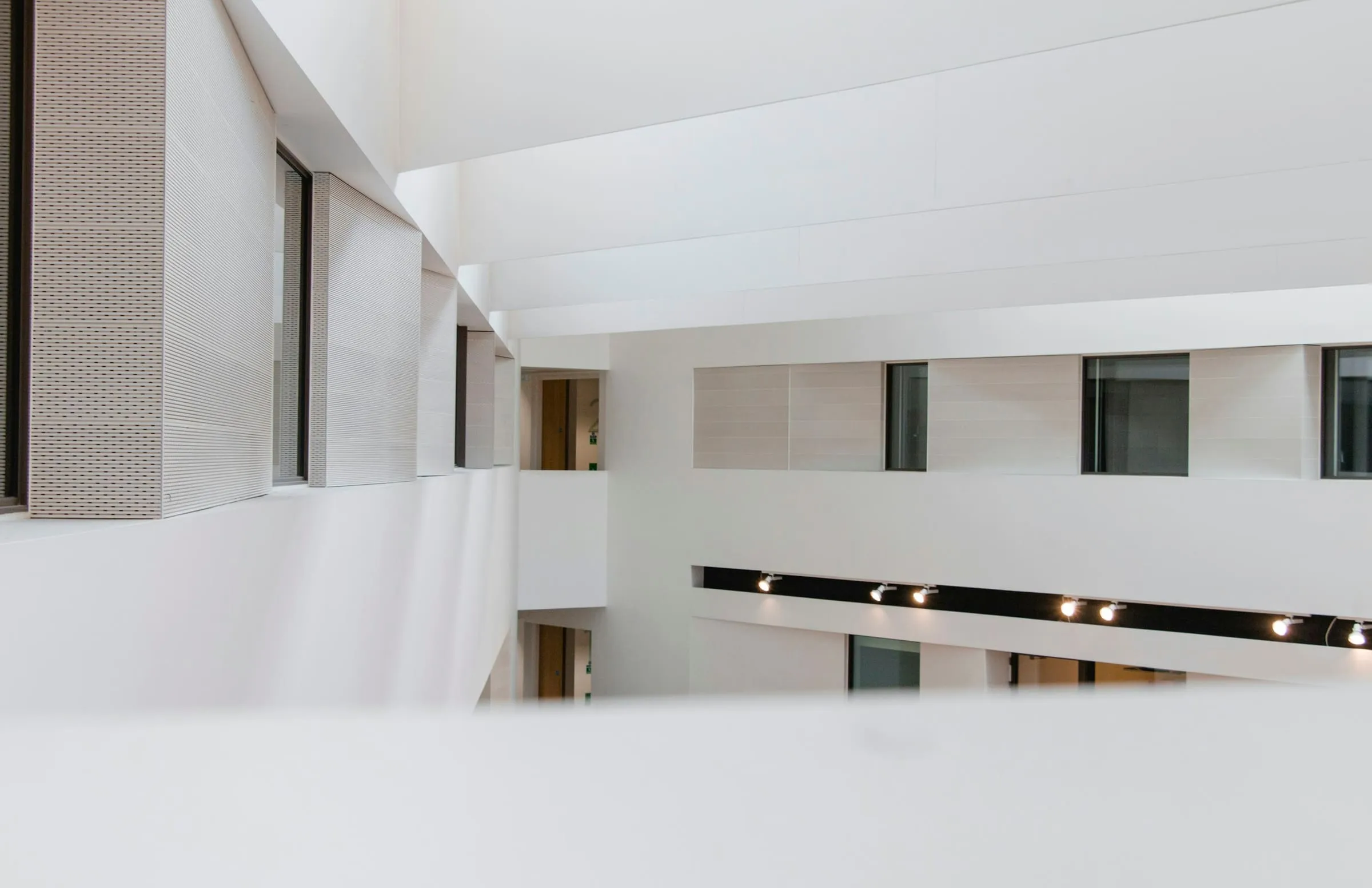A white concrete building whose long horizontal opening runs the width of the frame