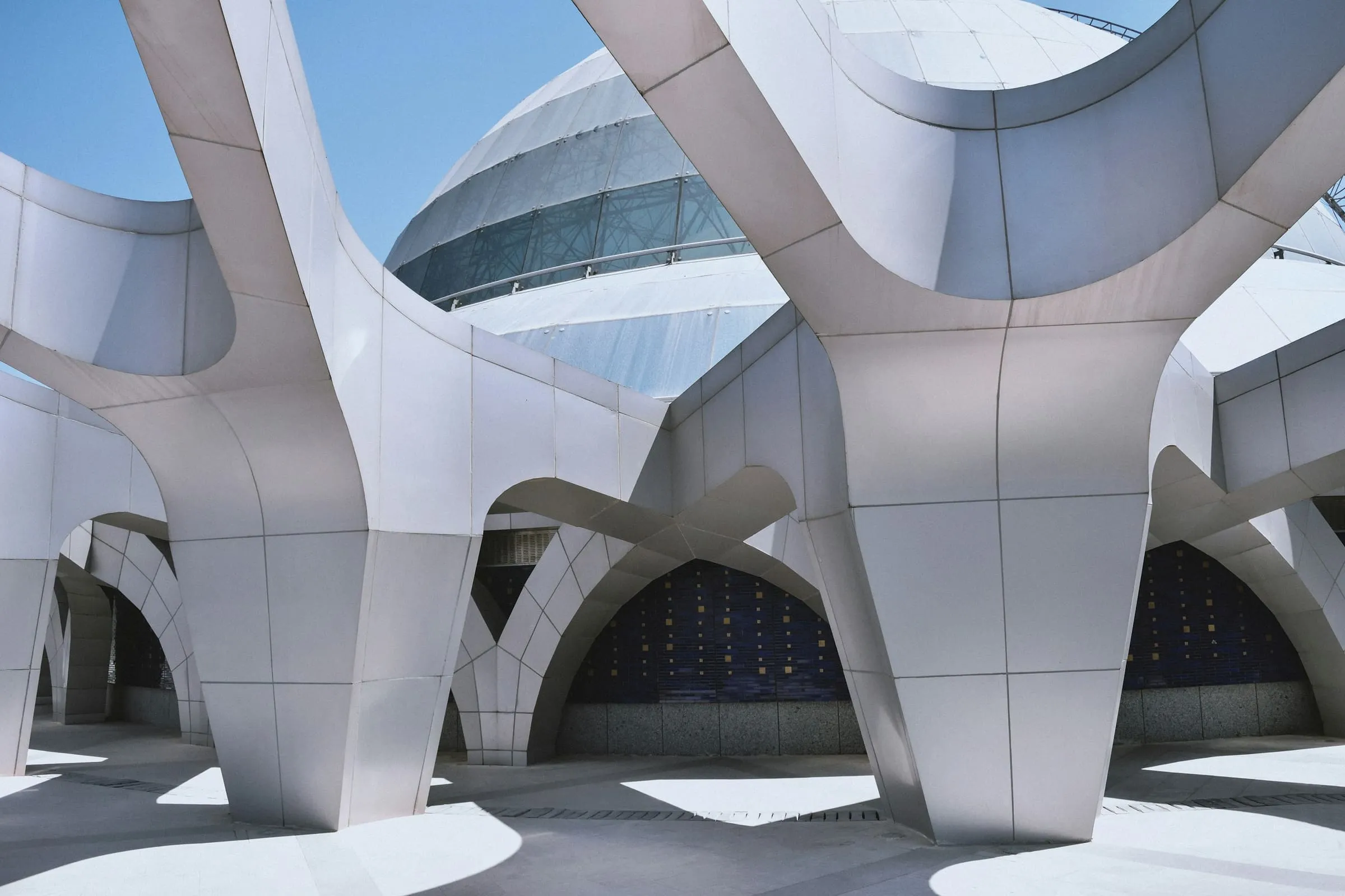 A white concrete building lit from one side, its openings cut cleanly into the wall